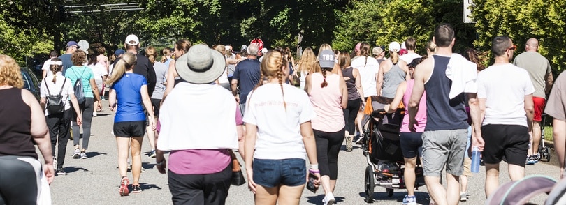 A diverse crowd of people walking together on a bustling city street