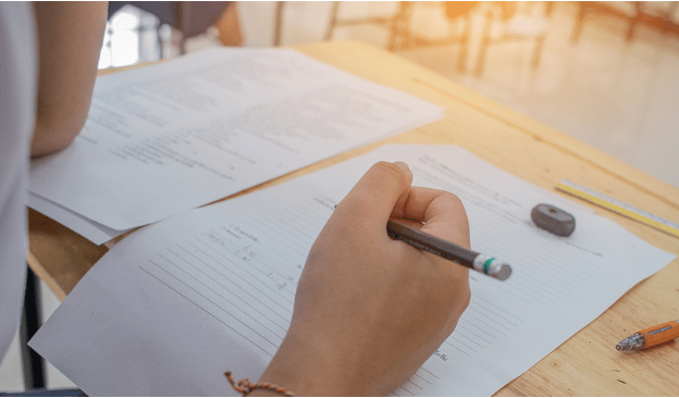 Student at desk taking a written exam