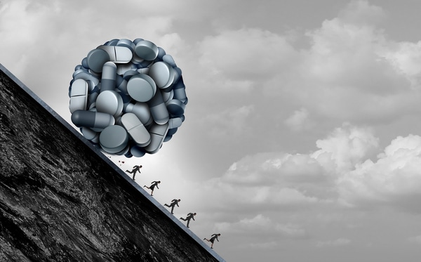 Artist rendition of a ball of pills rolling downhill at people running away