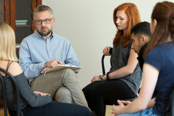 People seated in a circle during a therapy session