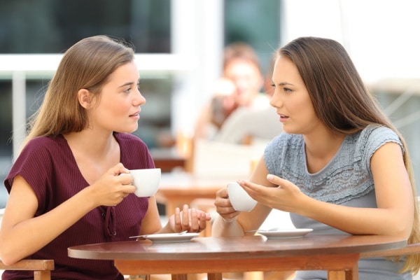 Two women in conversation over cups of tea