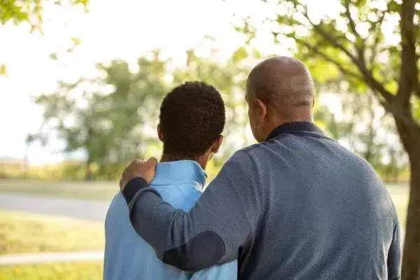 Father and son at the park, engaged in conversation