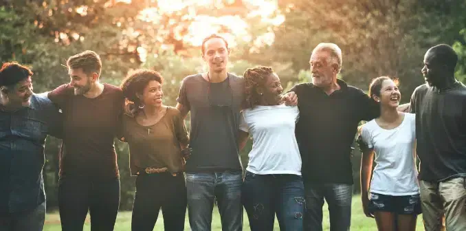 A group of people standing close together, with their hands resting on each other's shoulders