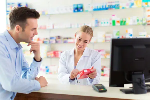A doctor pointing out medication to a man in a pharmacy shop