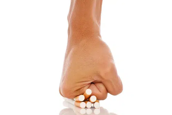 Cigarette crushed by a clenched fist, symbolizing the act of quitting smoking