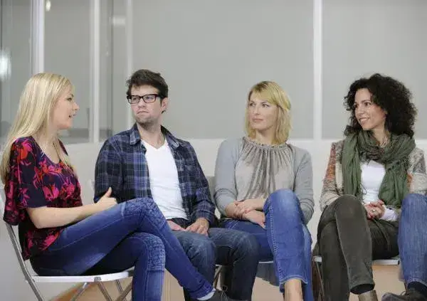 Four individuals engaged in a conversation while seated on chairs