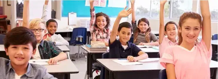 Group of students in classroom raising hands to ask questions