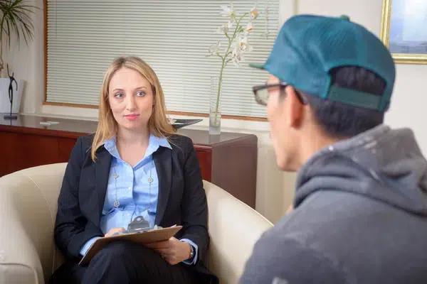 Professional woman in a suit discussing with a man in an office