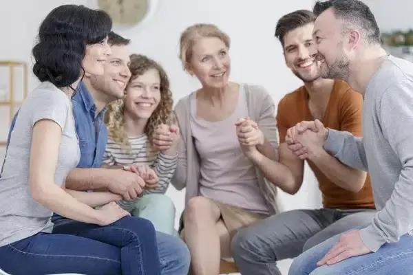 A diverse group of individuals holding hands and engaged in conversation