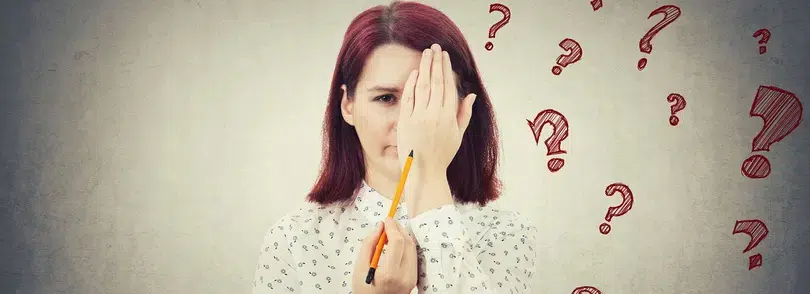 An image of a woman holding a pencil, with question marks swirling around her, while her hand is covering her face