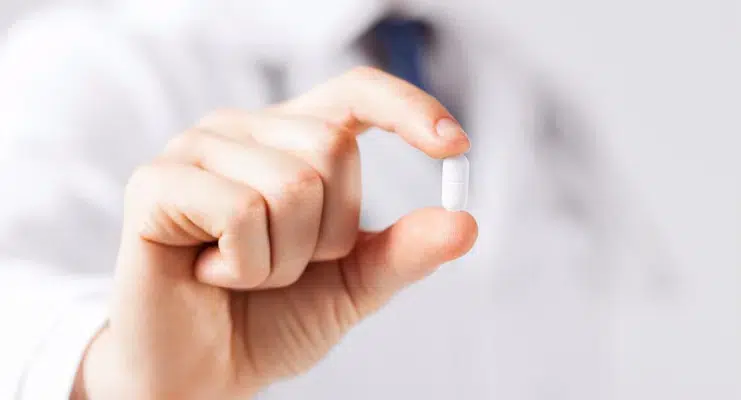 A man holding a pill in his hand