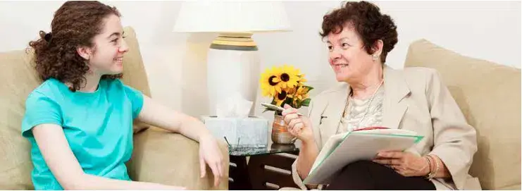 Two women engaged in conversation on a sofa