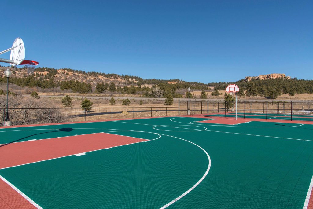 A rectangular playing area with a wooden floor, hoops at each end, and boundary lines for the game of basketball
